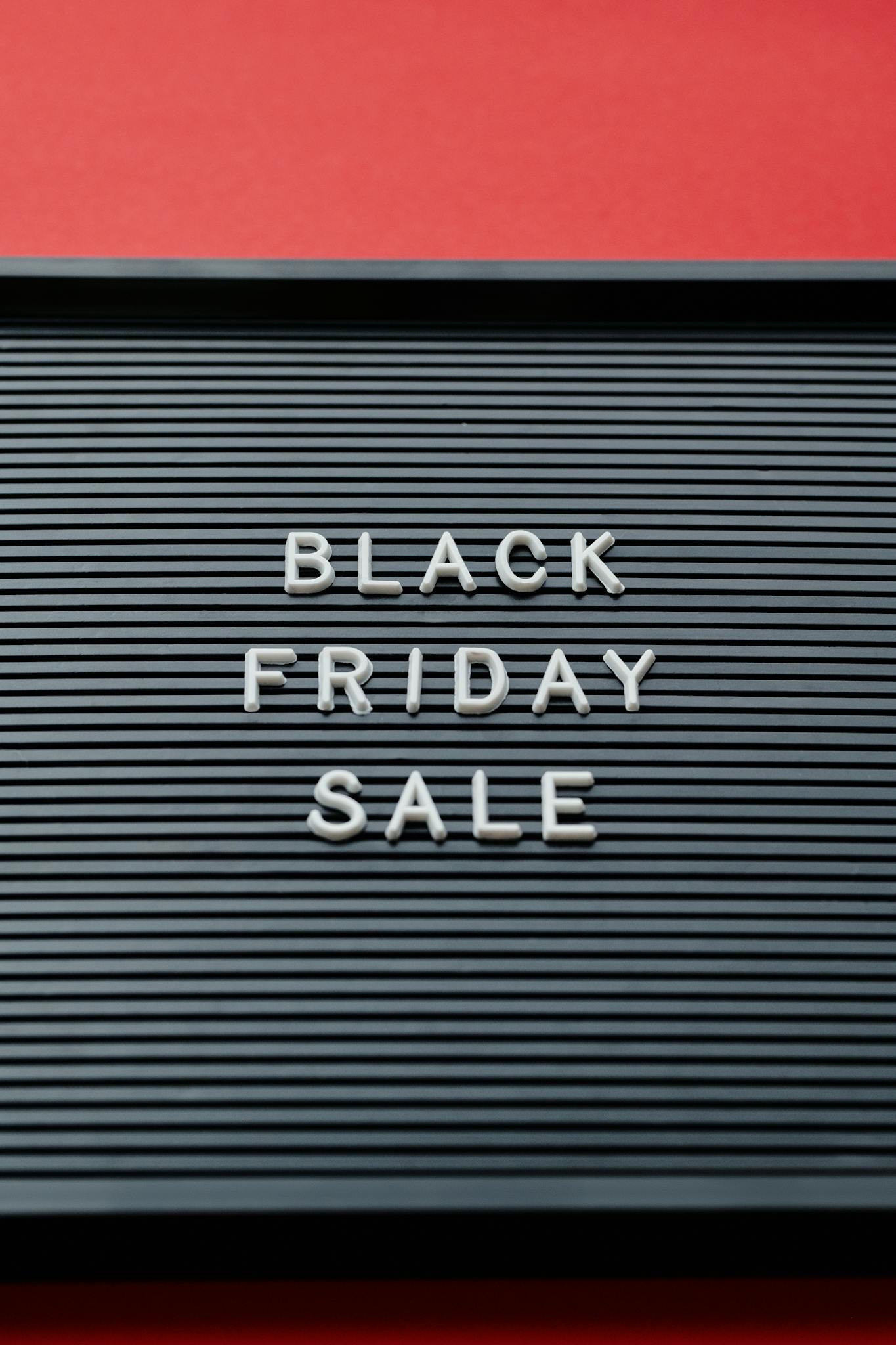 Black Friday sale sign on a letter board with a red background, concept for holiday shopping.