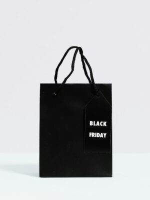 Black Friday shopping bag displayed on a minimalist background, perfect for sale promotions.